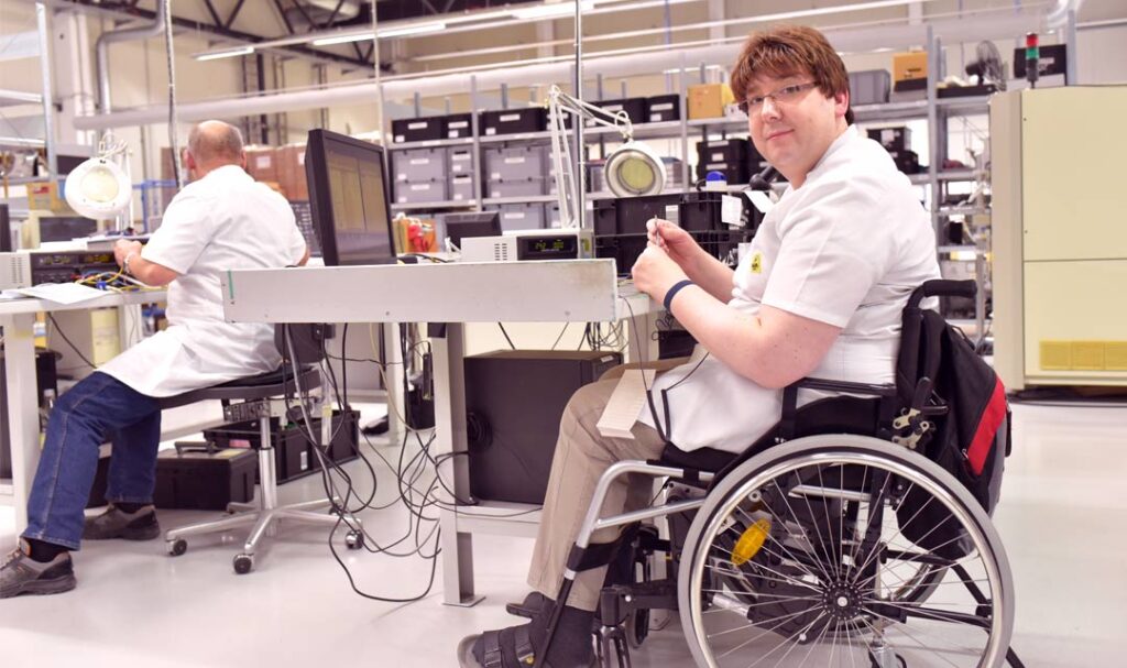 Man in wheel chair working on electronics